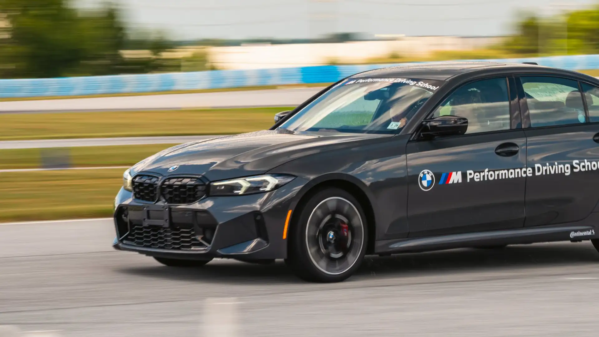 Dark grey BMW M340i at speed on the circuit