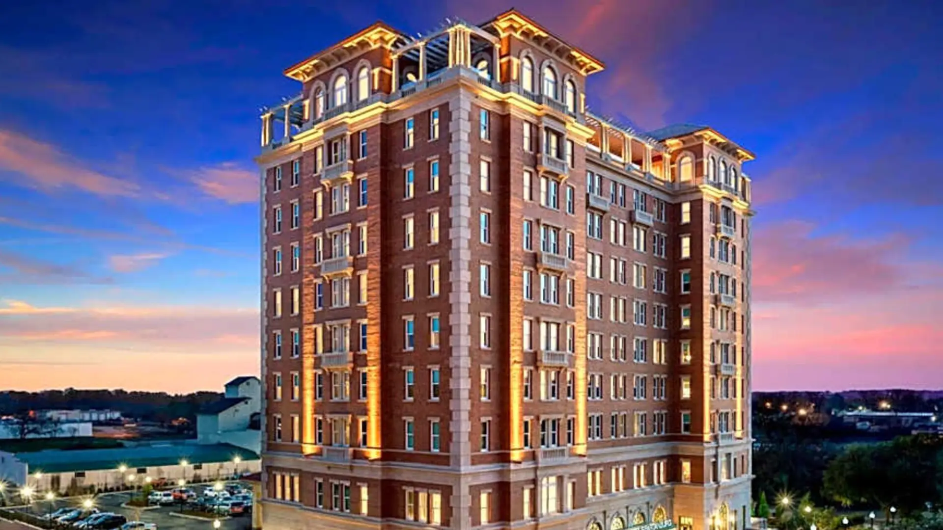 AC Hotel Spartanburg lit against a sunset sky
