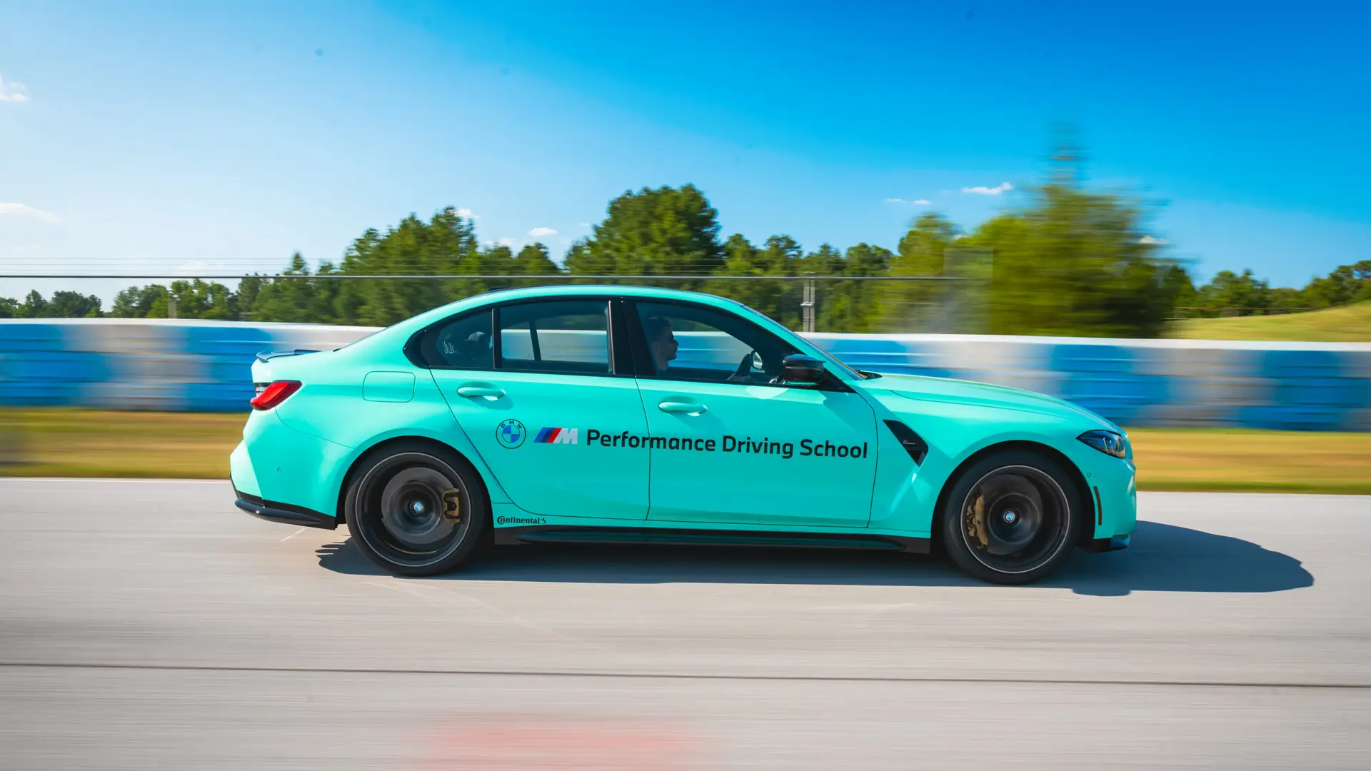Mint green BMW M3 at speed along the South Carolina circuit