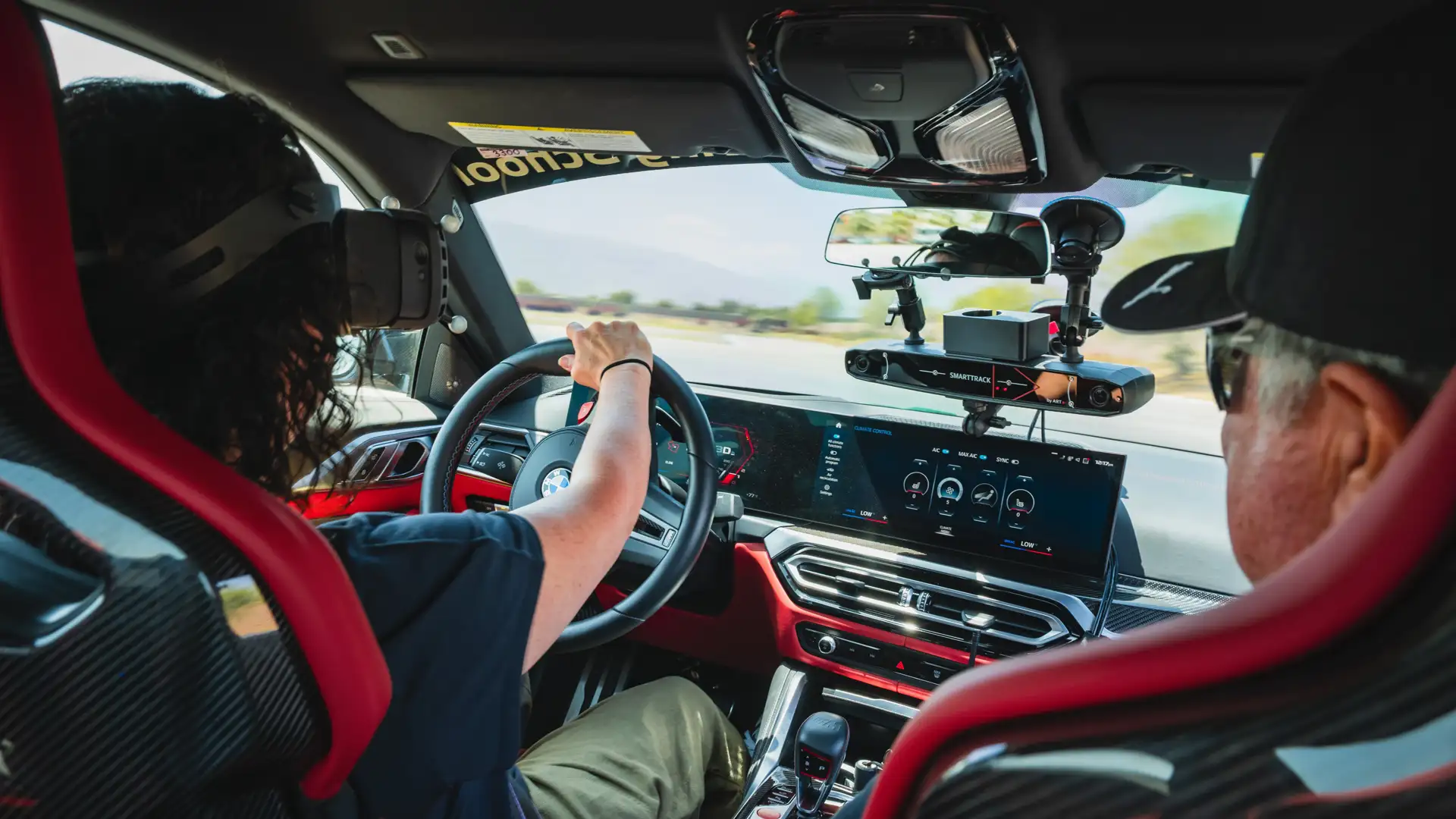 Driver wearing a mixed-reality headset at the wheel with an instructor alongside