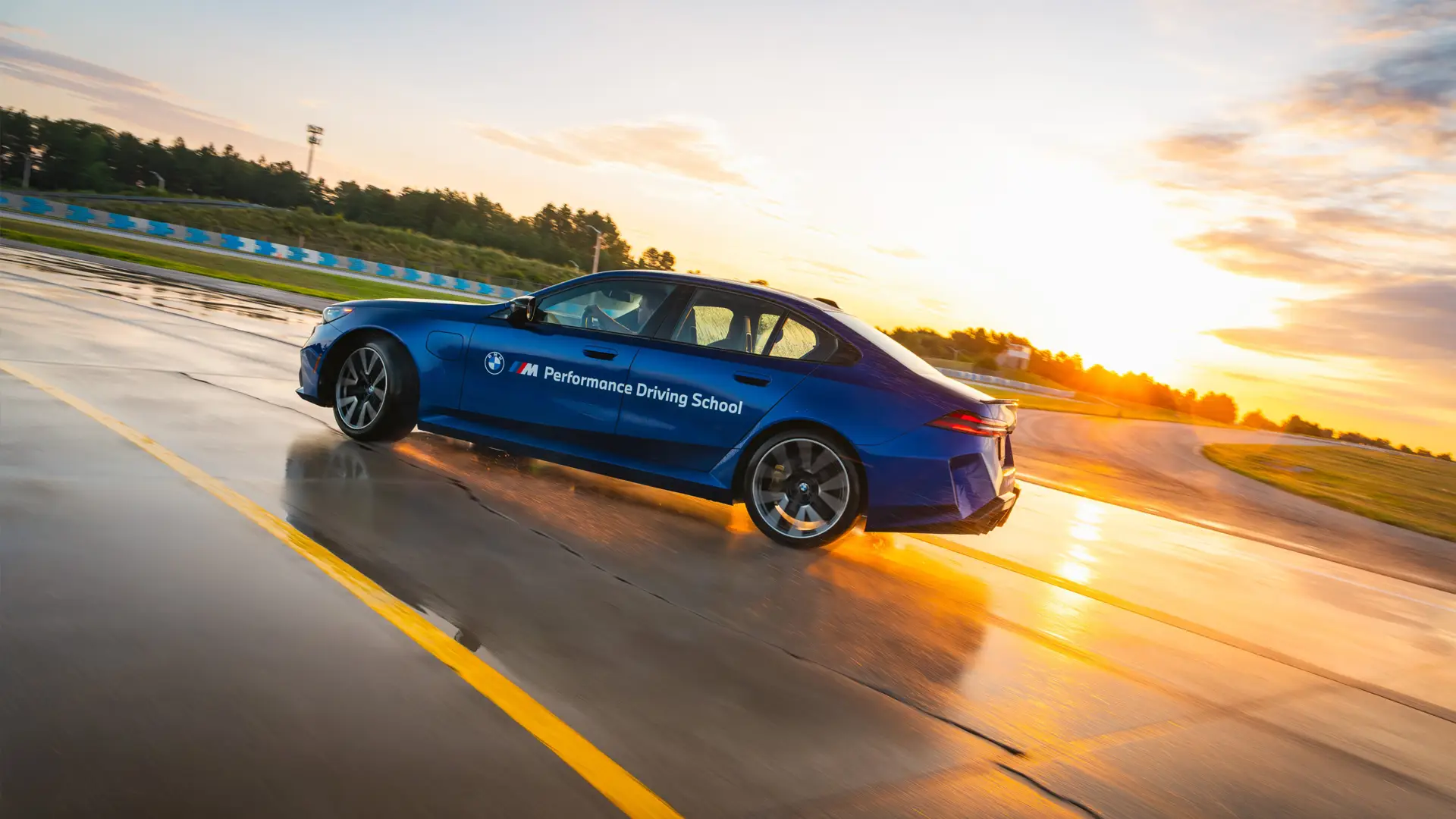 Blue BMW M5 on the wet circuit at sunset