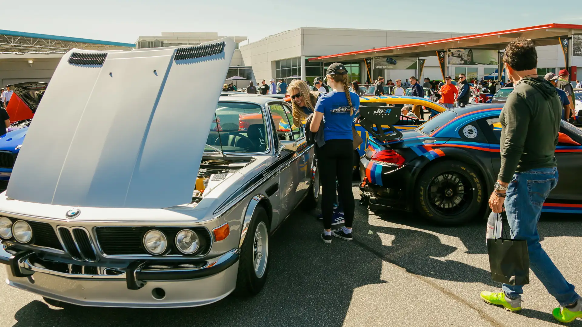 Classic BMW 3.0 CSL with its bonnet open at a car display, a race car alongside