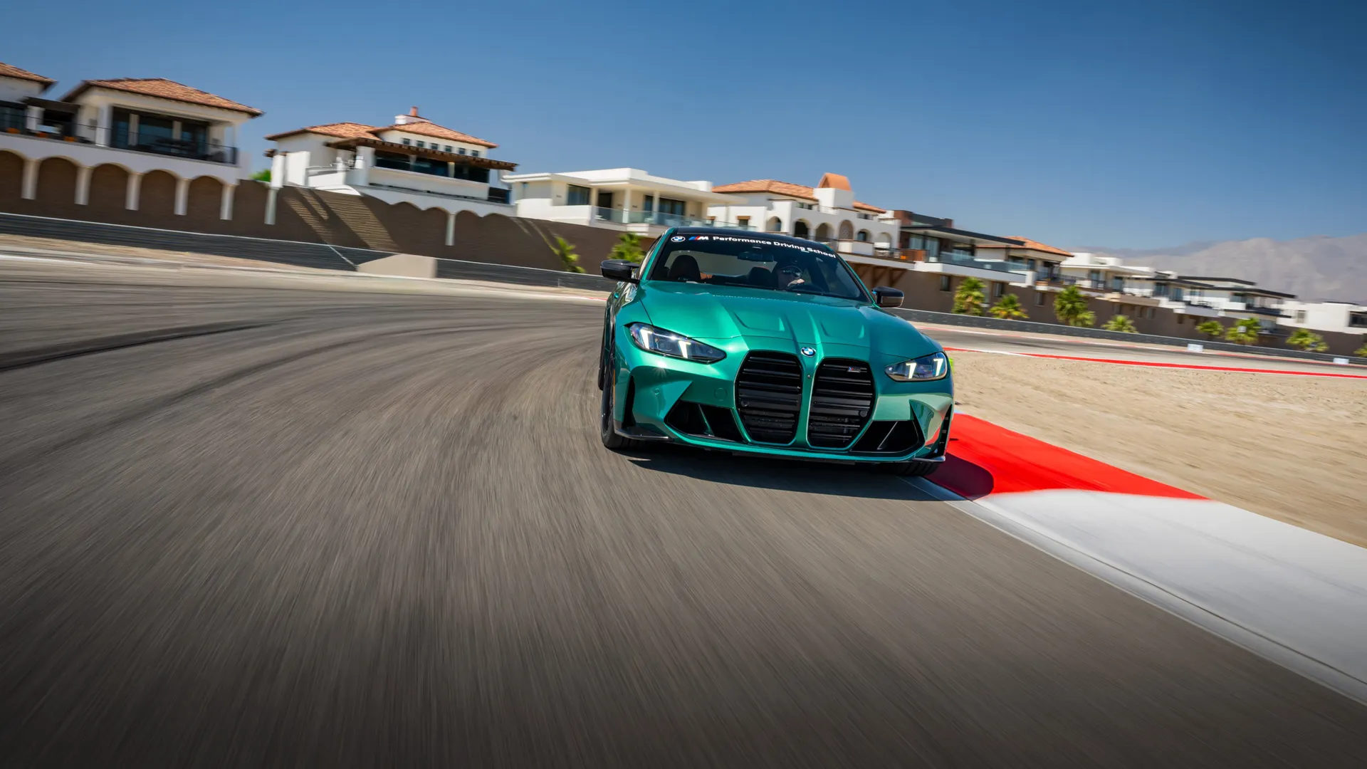Isle of Man Green BMW M4 cornering past the red kerbing