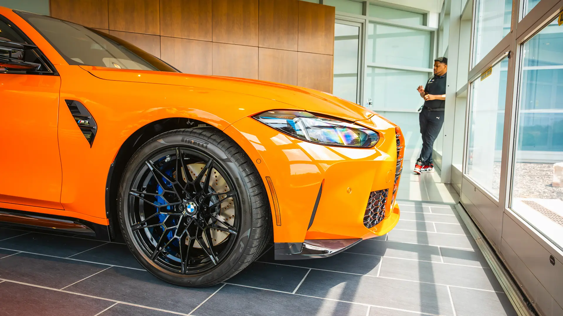 Orange BMW M4 in the delivery showroom