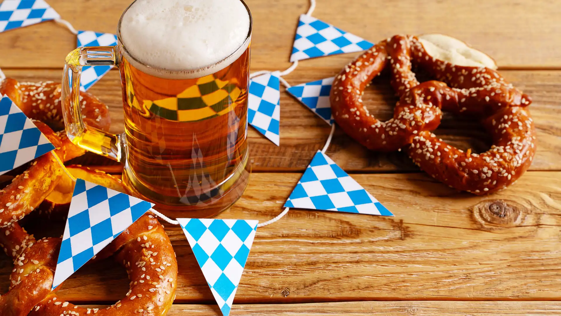 Beer stein and pretzels with Bavarian bunting on a wooden table