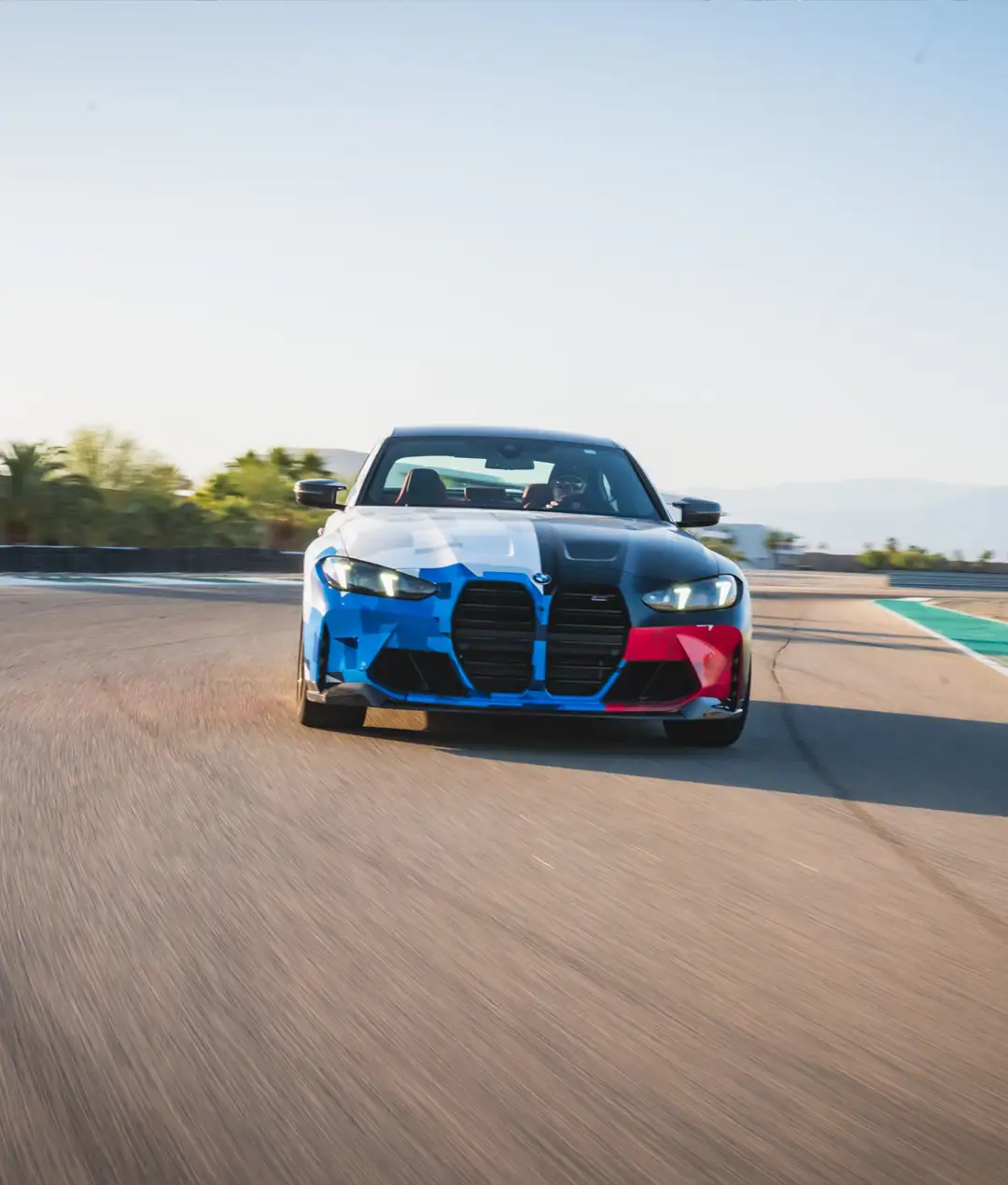 BMW M4 in Motorsport livery at speed on the desert circuit
