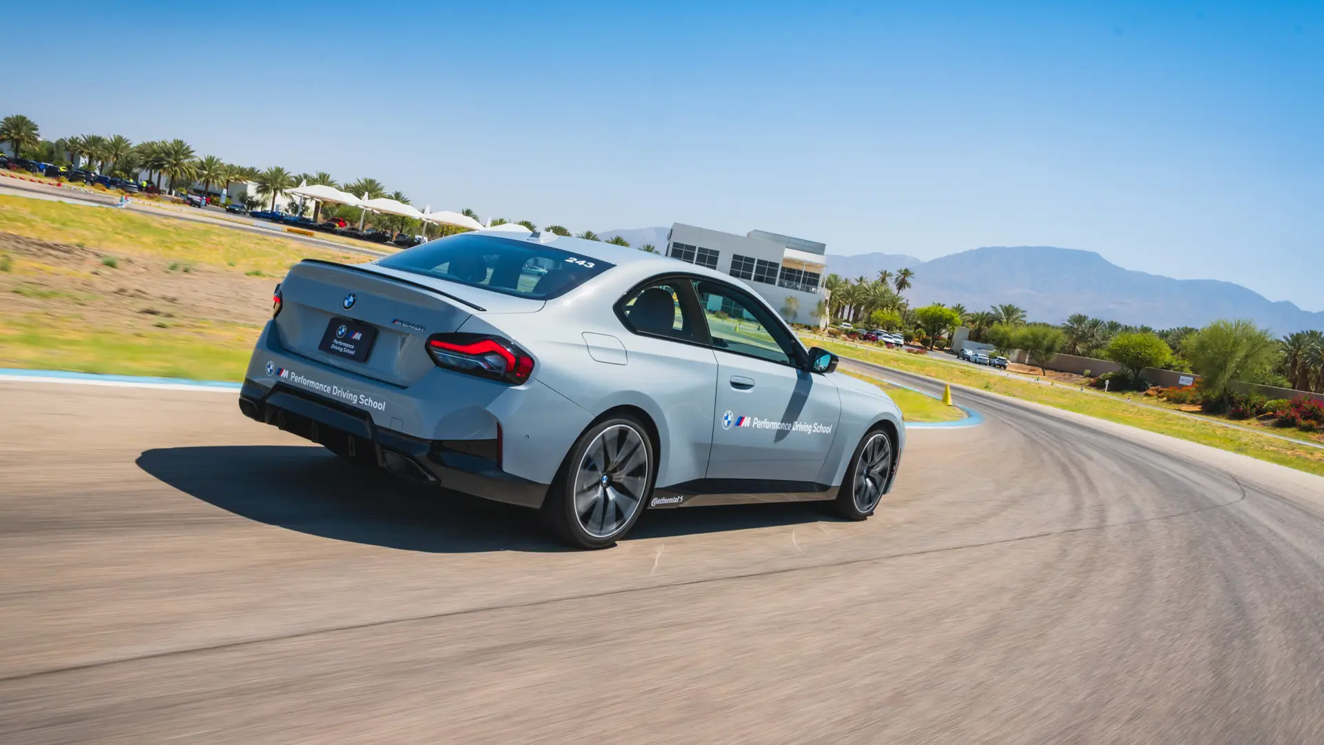 Grey BMW M2 accelerating away along the desert circuit