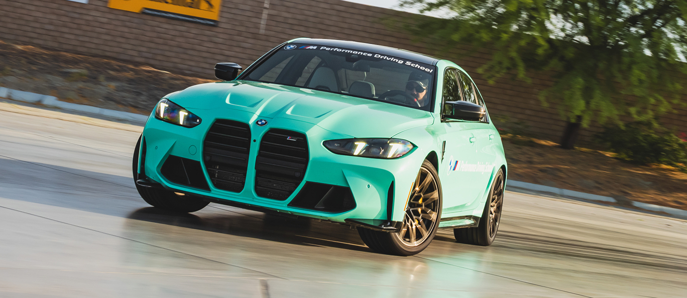 Mint green BMW M3 cornering on the wet apron