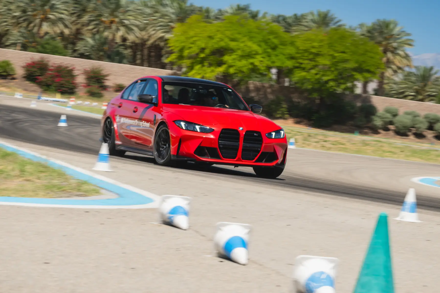 Red BMW M3 running a coned course on the desert circuit