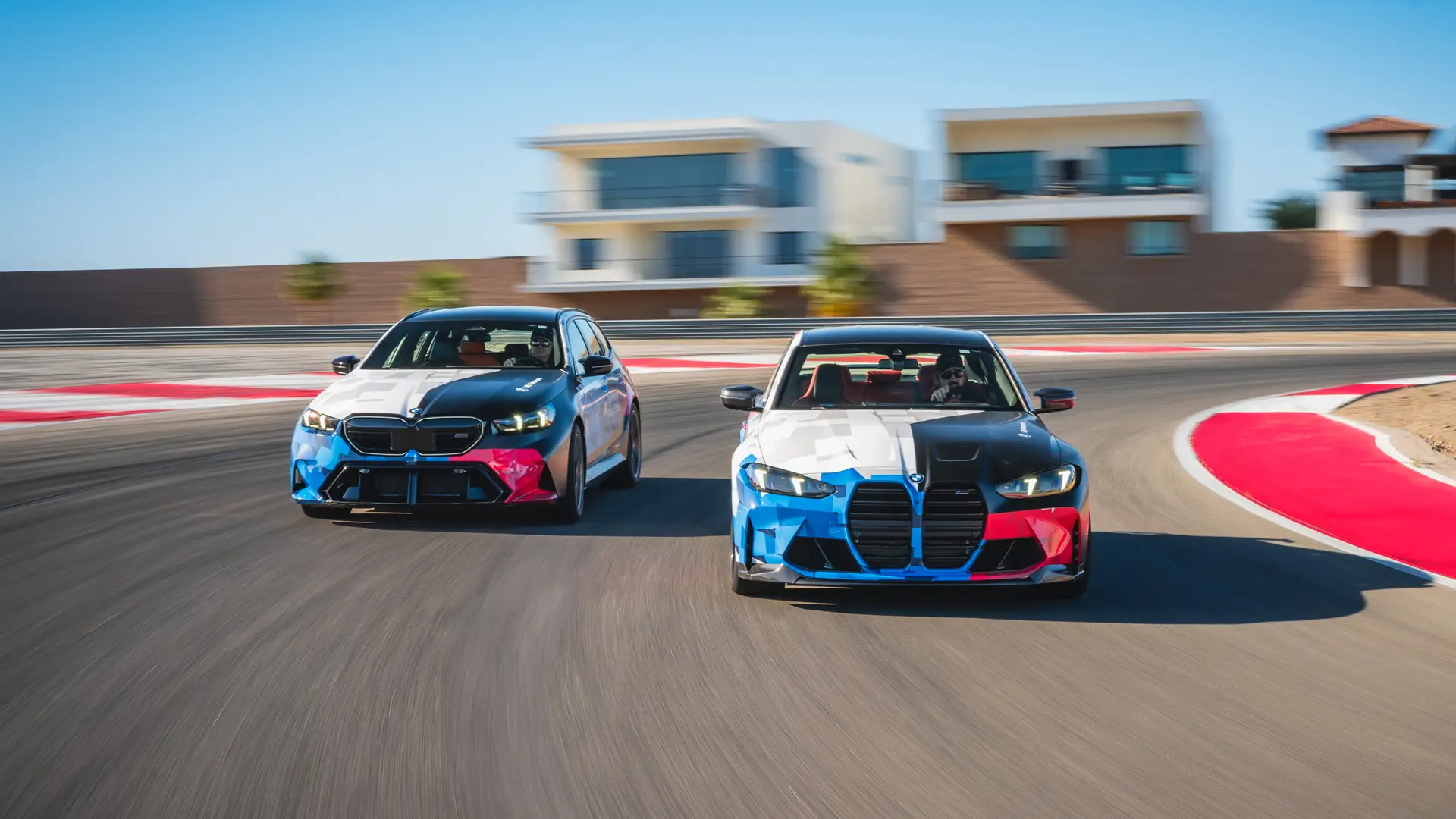 BMW M5 Touring and M3 in Motorsport livery running side by side through a corner
