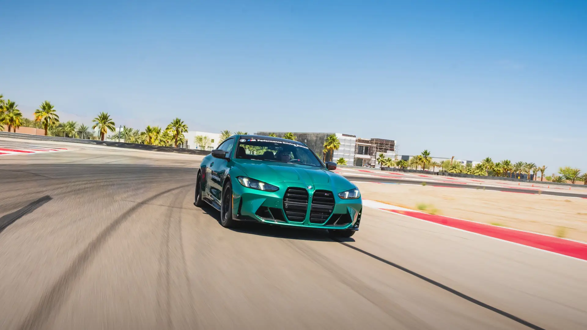 Green BMW M4 cornering on the desert circuit