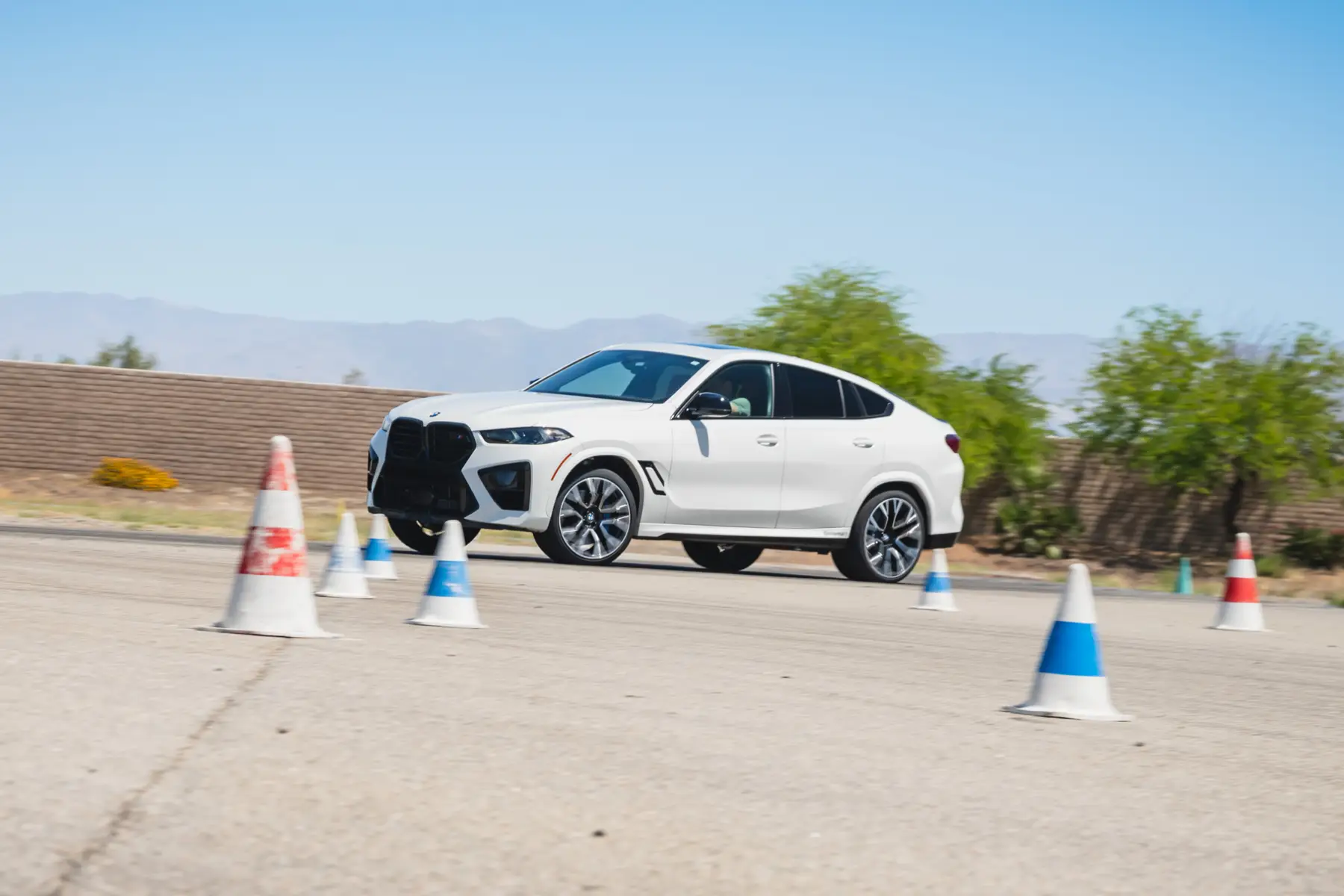 White BMW X6 M threading a coned course in the desert