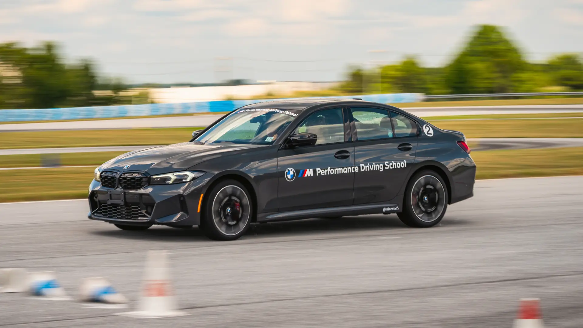 Dark BMW M340i at speed on the South Carolina circuit