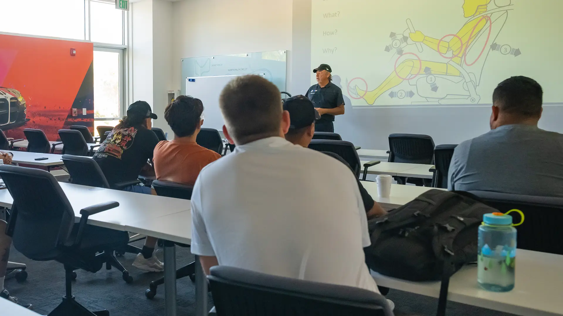 Instructor presenting a vehicle-dynamics diagram to a classroom of students