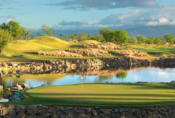 Golf green beside a lake at PGA WEST with the mountains beyond